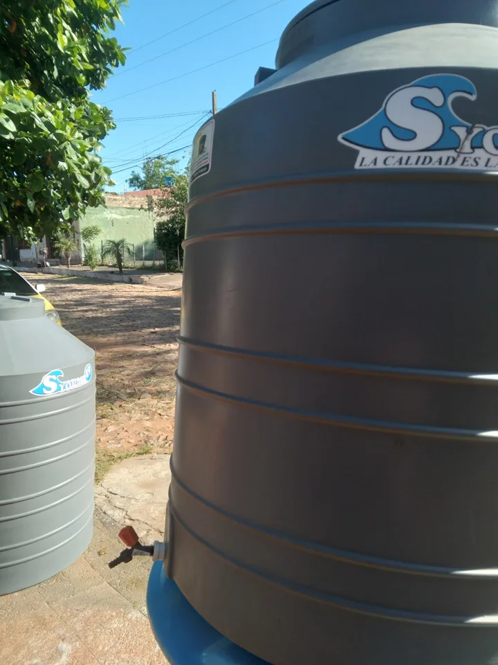 Tanque de agua gris en la vereda de la ferretería